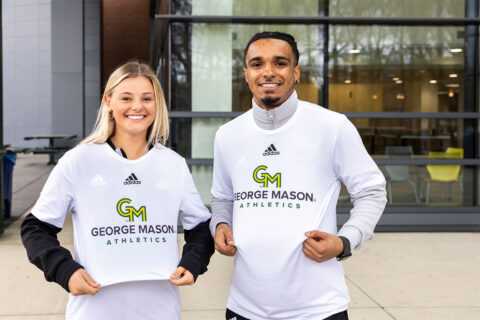 Students display shirts with new GMU logo