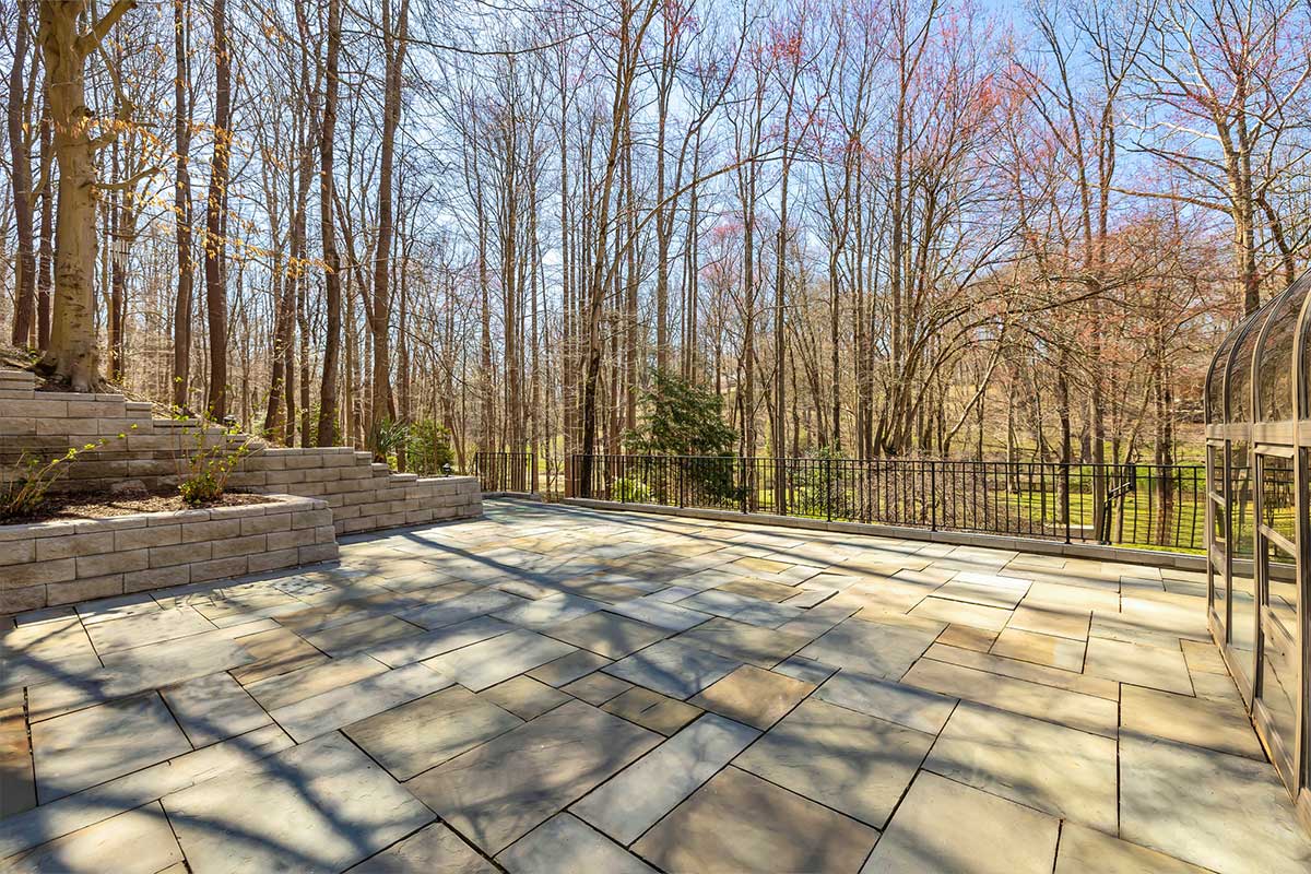 stone patio with view of backyard and trees