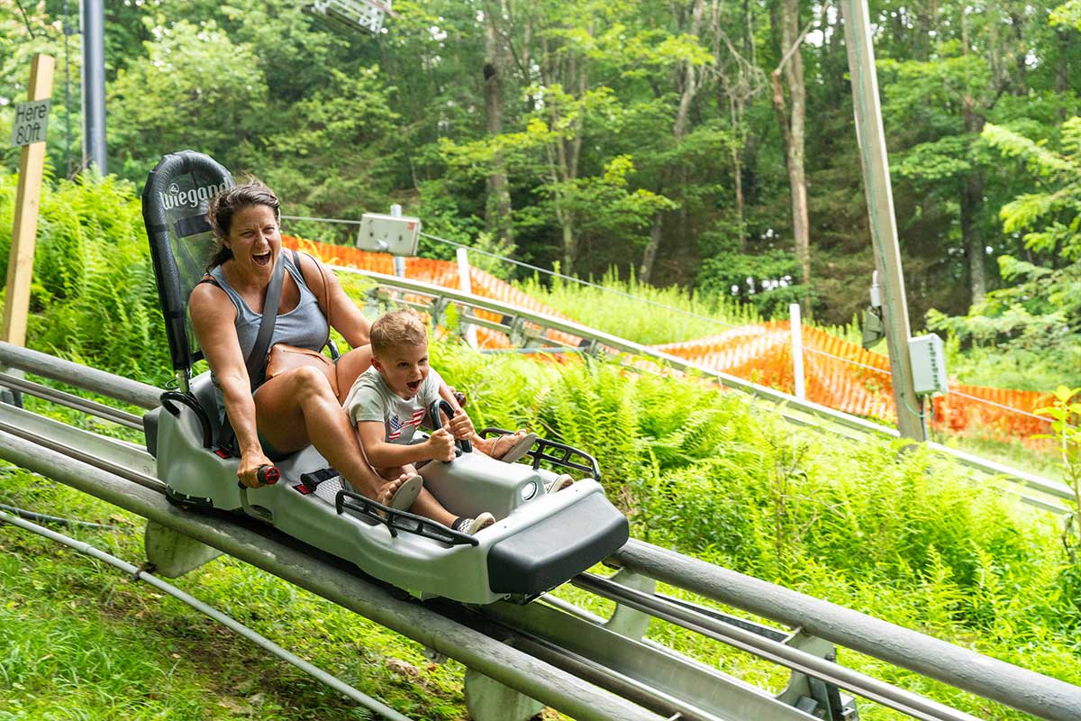 mom and son riding mountain coaster at Wisp resort