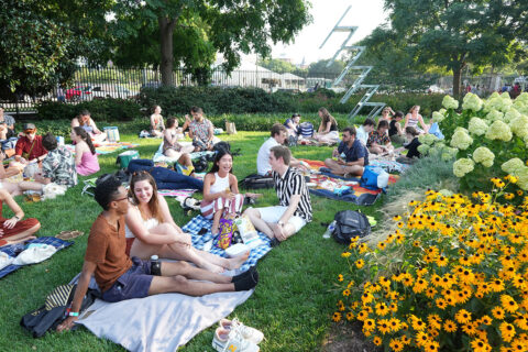 Jazz in the Garden attendees sit on blankets