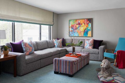 play room with grey couch and colorful pillows
