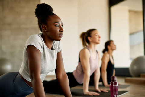 Women exercising, stretching on floor