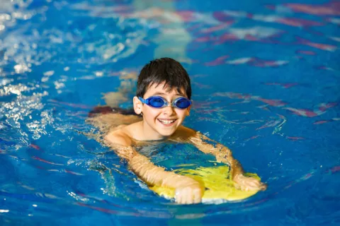 Boy in pool with swimming goggles on