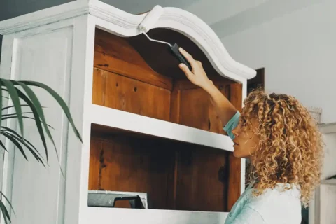 woman painting wood cabinet white