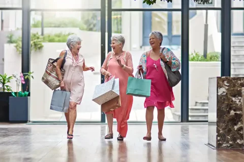 three senior women with shopping bags