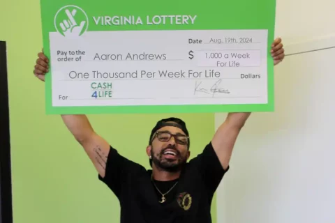 Aaron Andrews hold winning lottery check