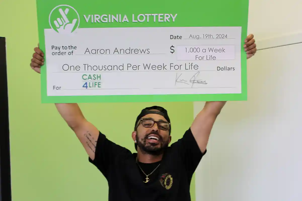 Aaron Andrews hold winning lottery check