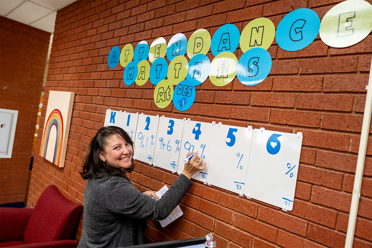 Teacher filling out attendance chart
