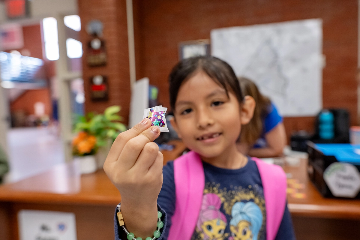 Student holds up stickers