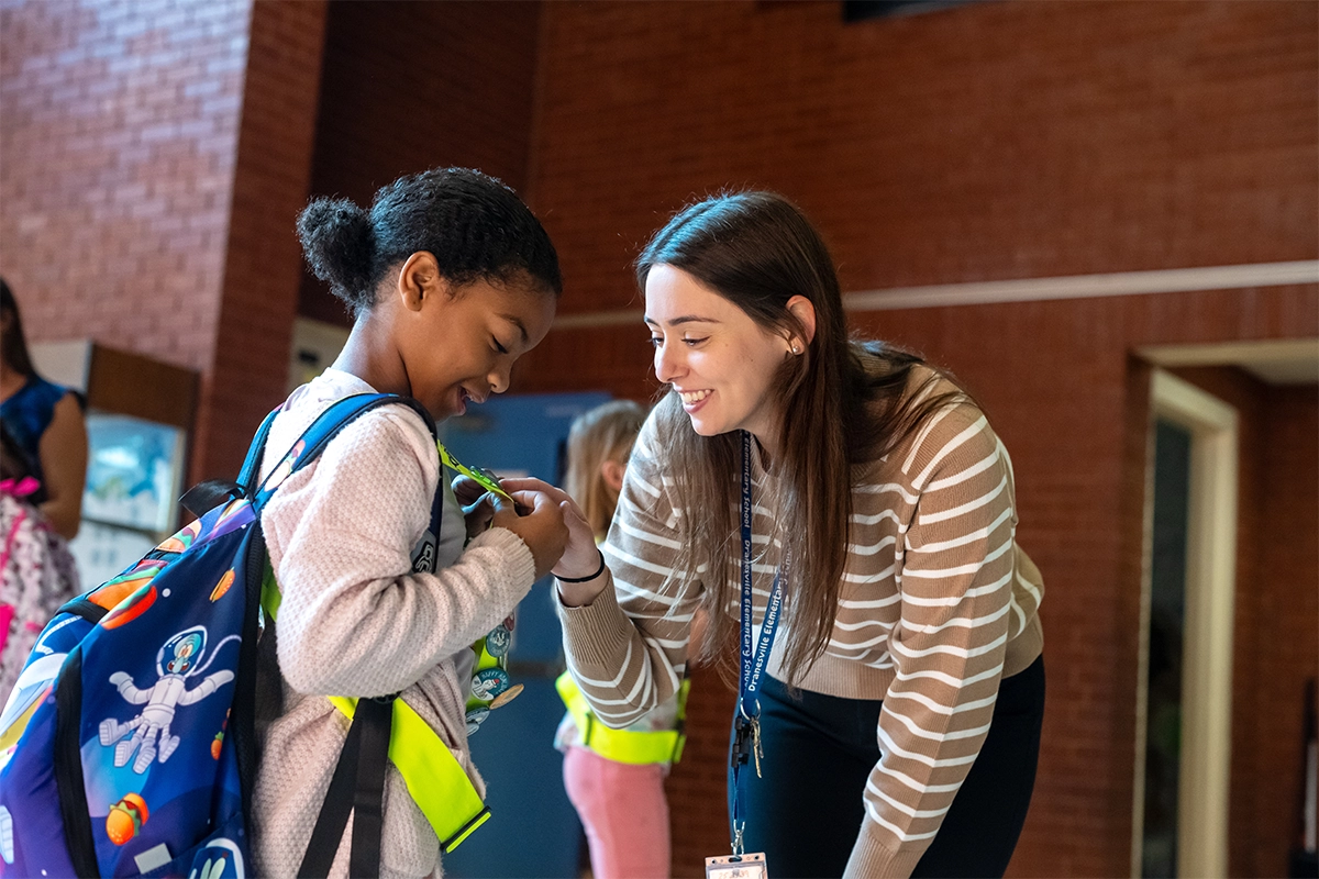 Teacher greets student.