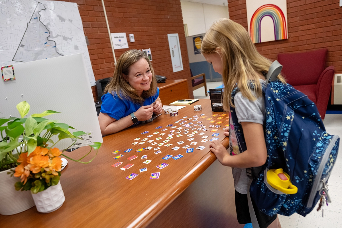 A student grabs a sticker from the school registrar on the way to class.