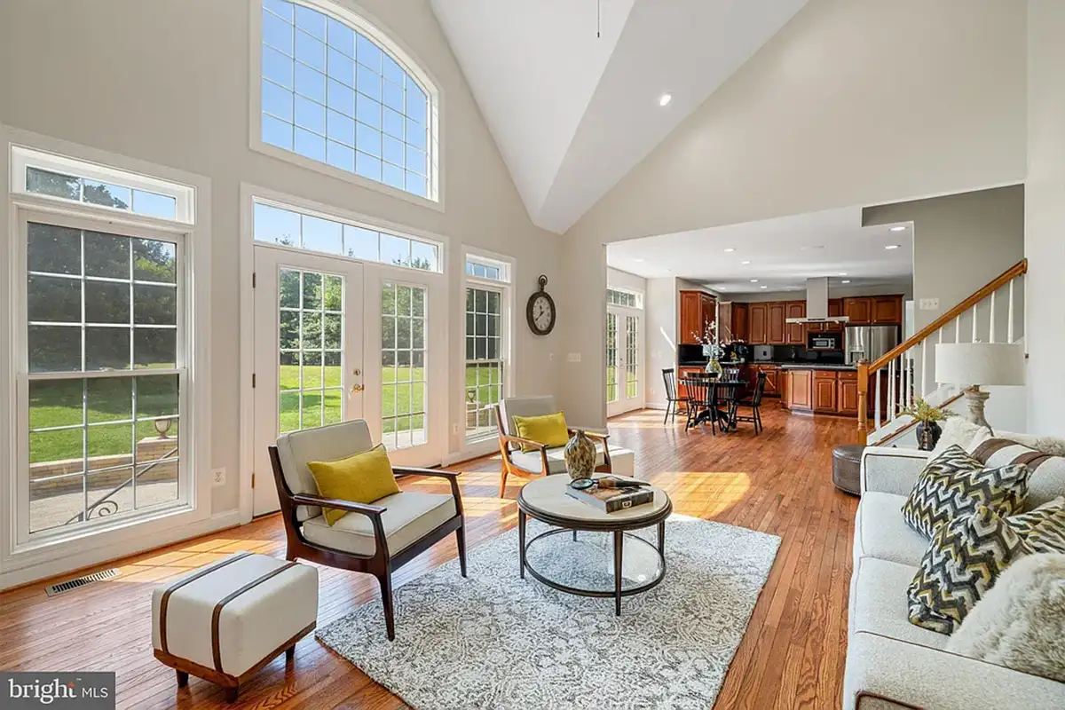 Living room with chairs with yellow pillows. Large windows.
