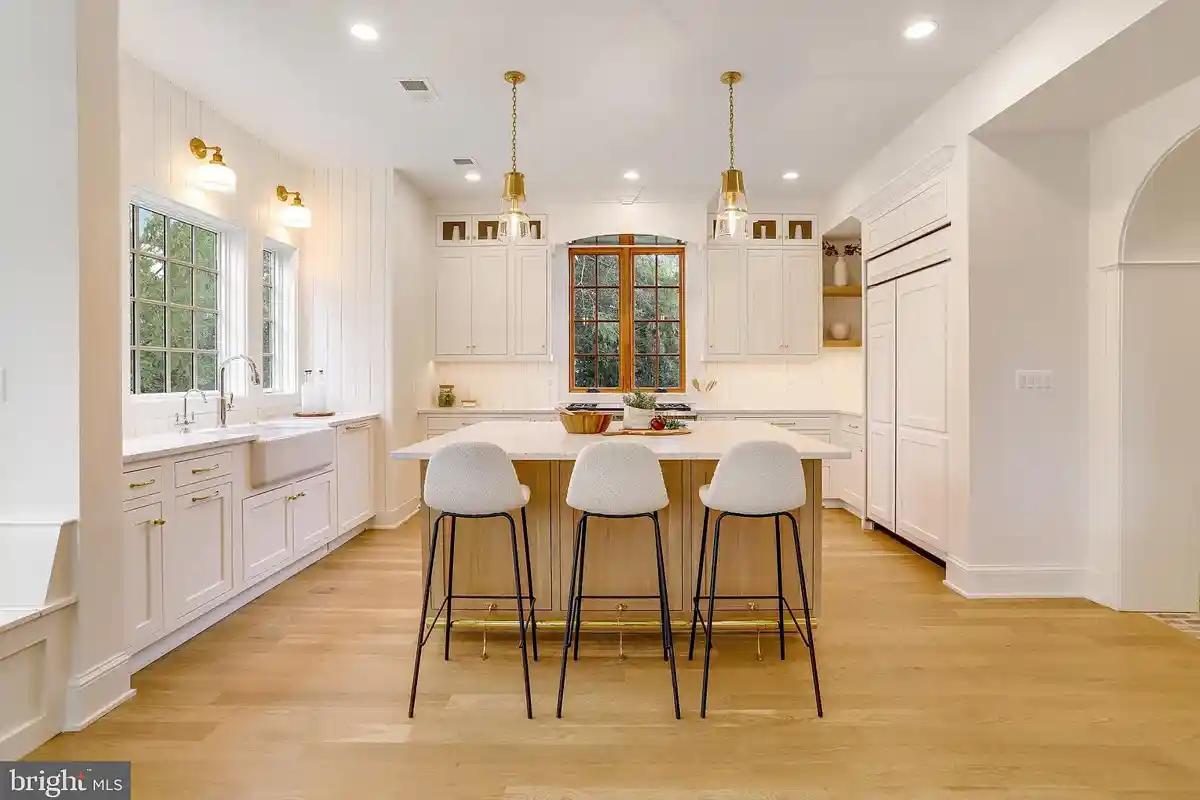 kitchen with white cabinets and island with bar stools