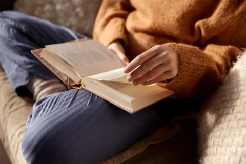Woman reading book on couch