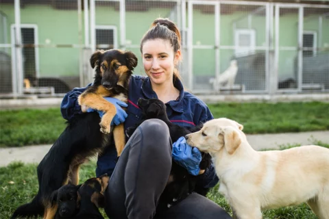 woman hugging two dogs
