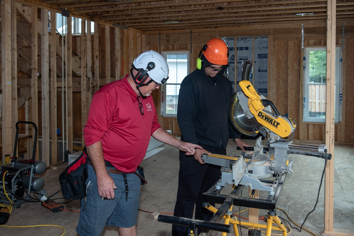 Teacher and student using power tools at Spring Village Estates