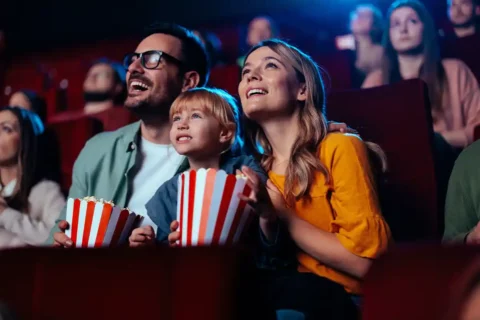 family with popcorn at movie theater