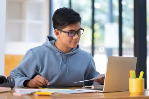 student writing essay on laptop