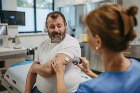 doctor checking man's glucose levels