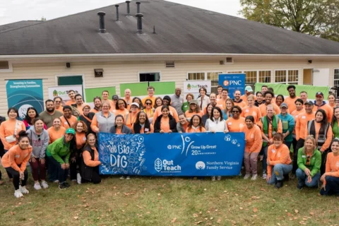 Volunteers for Early Education Center outdoor lab groundbreaking posing in front of the center
