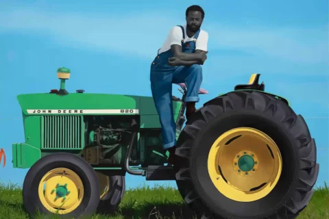 painting of black man standing on tractor by Amy Sherald