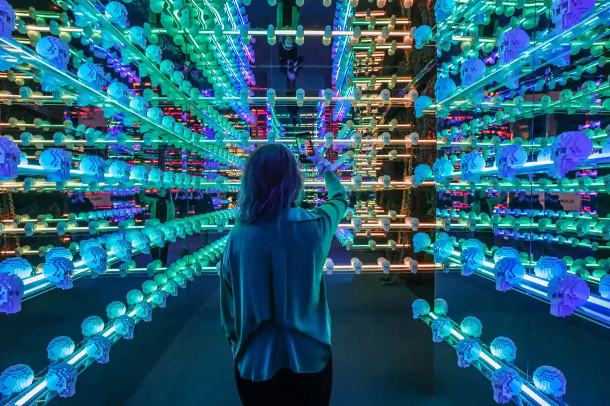 woman taking picture of lighted lego skulls
