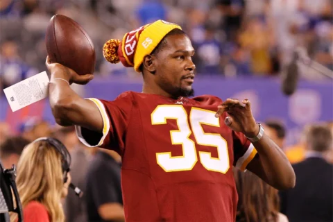 NBA player Kevin Durant throws the ball around while in a Washington Redskins jersey and hat during warm-ups prior to the NFL game between the Washington Redskins and the New York Giants at MetLife Stadium in East Rutherford, New Jersey.