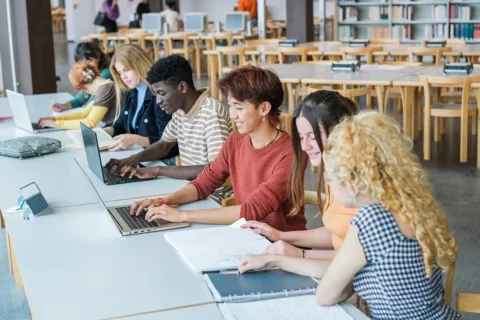 Teenagers work on laptops at school