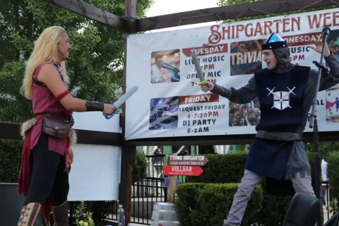 Two men duel with swords on stage at a Renaissance Fair at Shipgarten