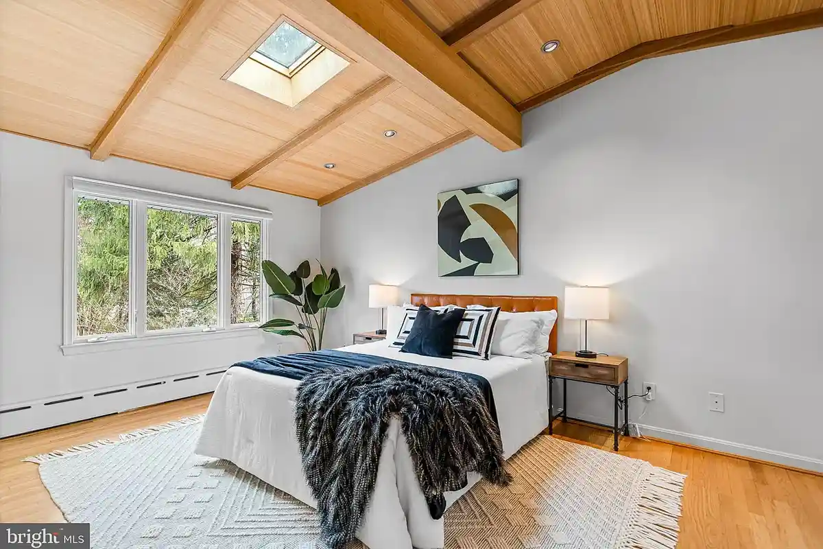 bedroom with wood vaulted ceilings and skylight