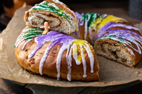 A sliced King Cake with plastic baby