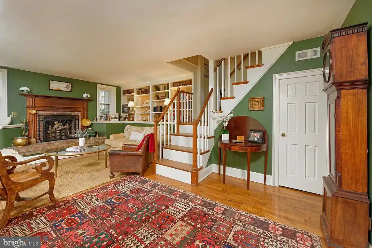 living room with raised fireplace and staircase to upper level