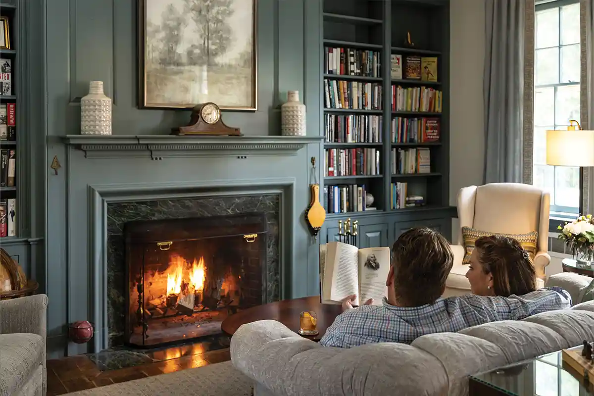 people reading in front of fireplace at Great Oak Manor