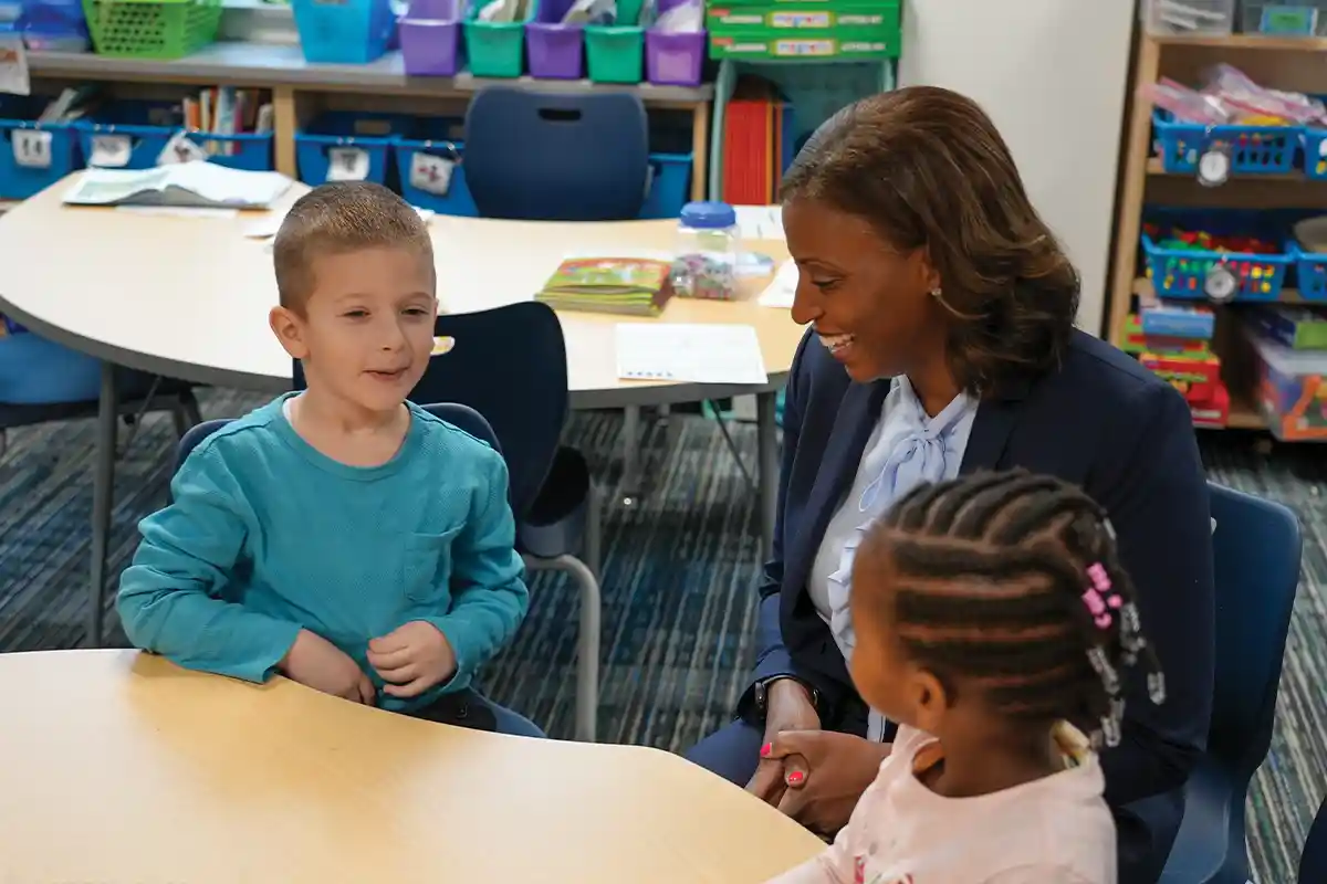 Latanya McDade sits at the table with elementary school students