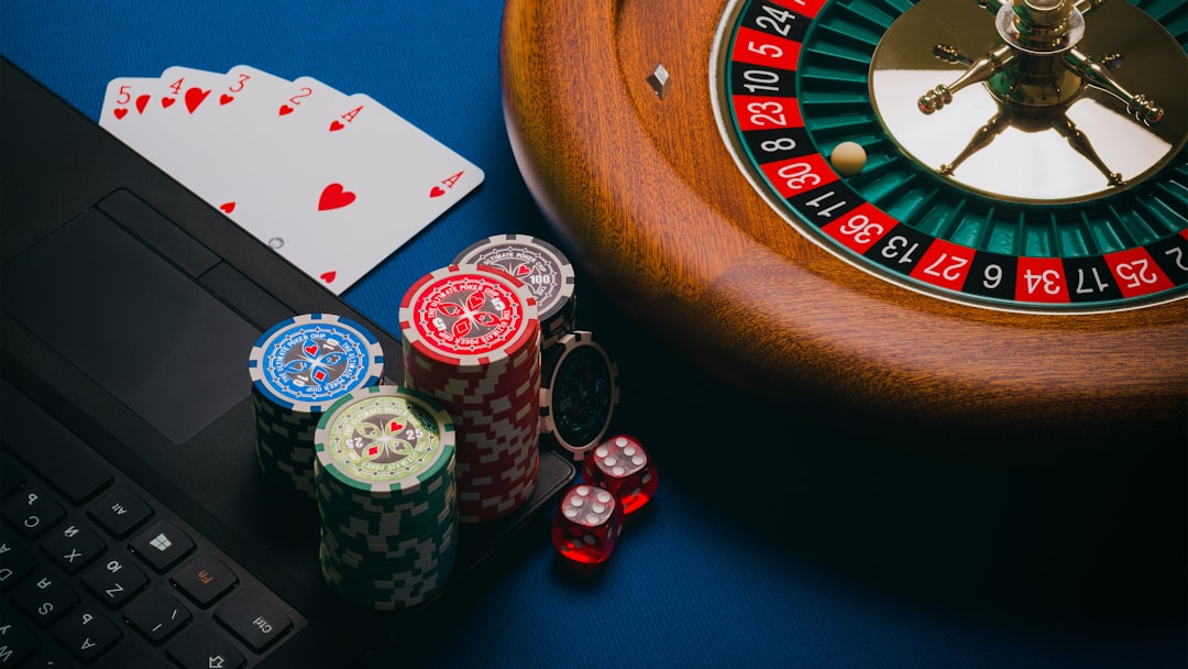 gambling image of playing cards, chips and a roulette wheel on brown wooden table