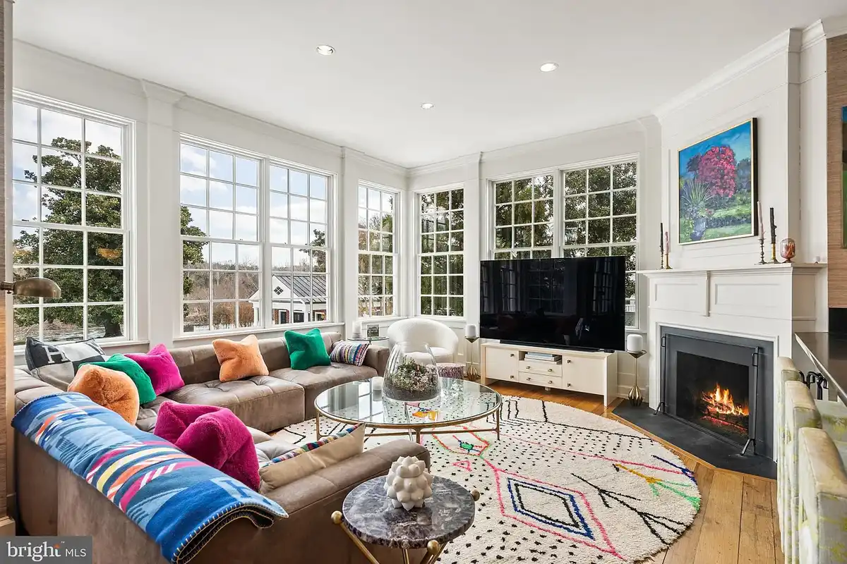family room with wall of window and l-shaped couch covered in colorful pillows