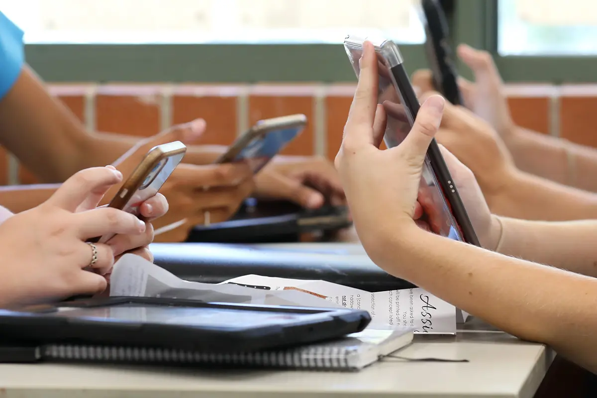 kids type on cell phones at a table