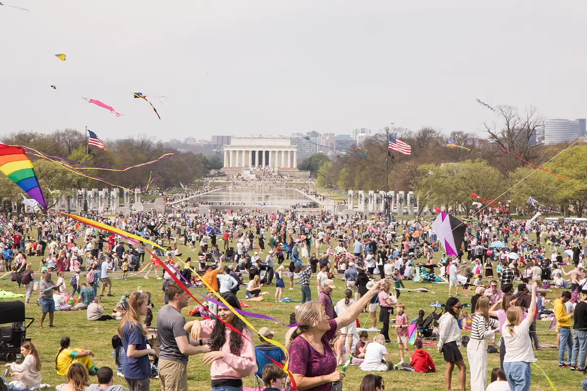 the national mall filled with people flying kites with the Lincoln Memorial in the background