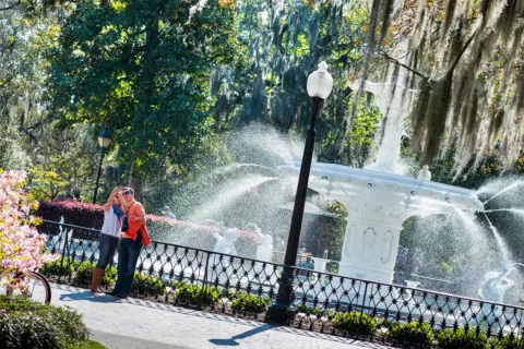 A couple takes a selfie in front of a fountain in Savannah