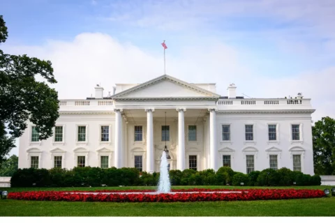 White House in Washington DC in Spring/Summer with fountain on and red flowers out front