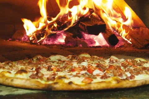 pizza in brick oven at The Dons' Wood-Fired Pizza