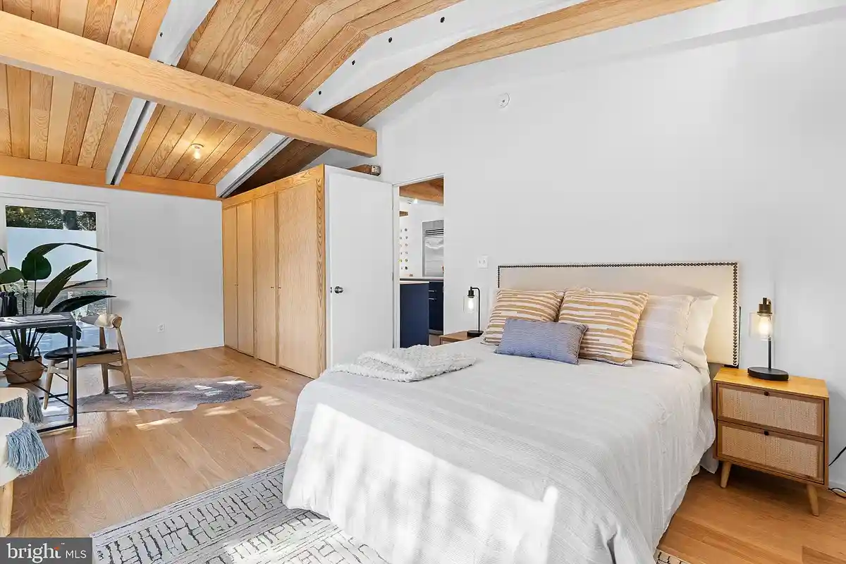 primary bedroom with beamed ceilings and lounge area