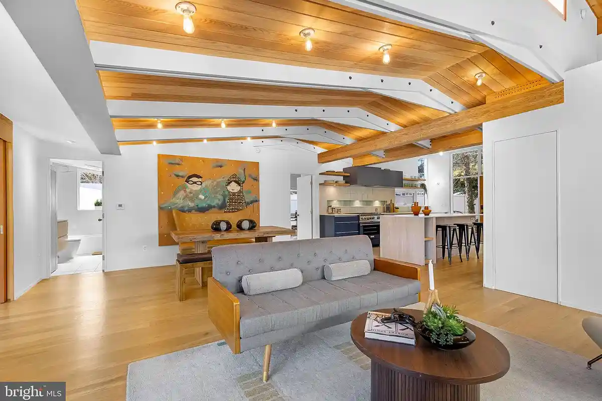 living room with beamed ceilings and opens up to dining area