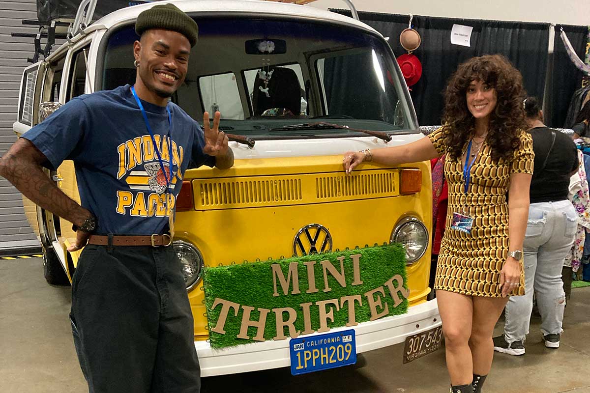 two people standing in front of vintage VW bus