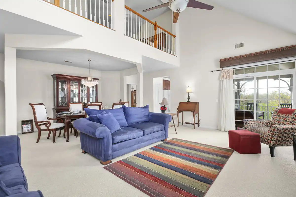 living room with blue couch and cream colored carpets