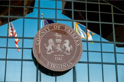 close up image of Fairfax County seal on the exterior of a glass office building