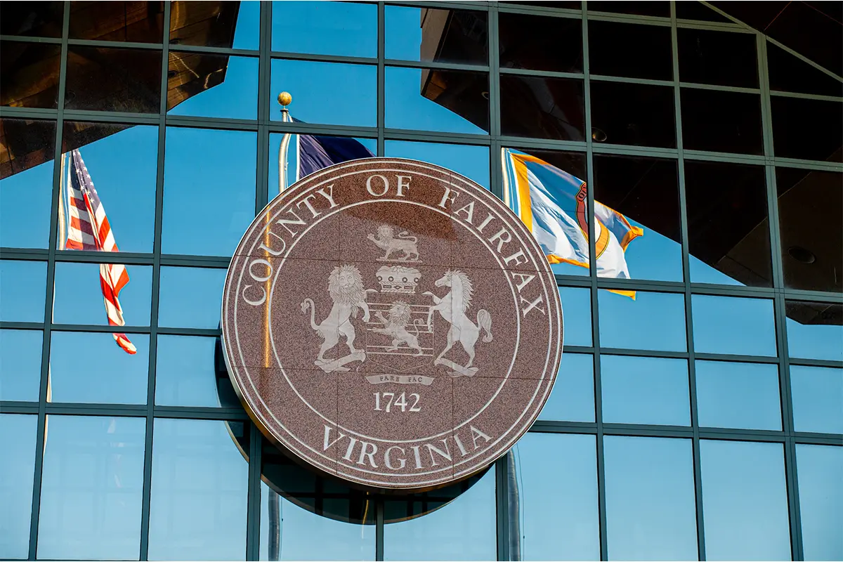close up image of Fairfax County seal on the exterior of a glass office building