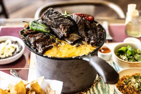 Pot filled with rice, cheese and meat at Ometeo
