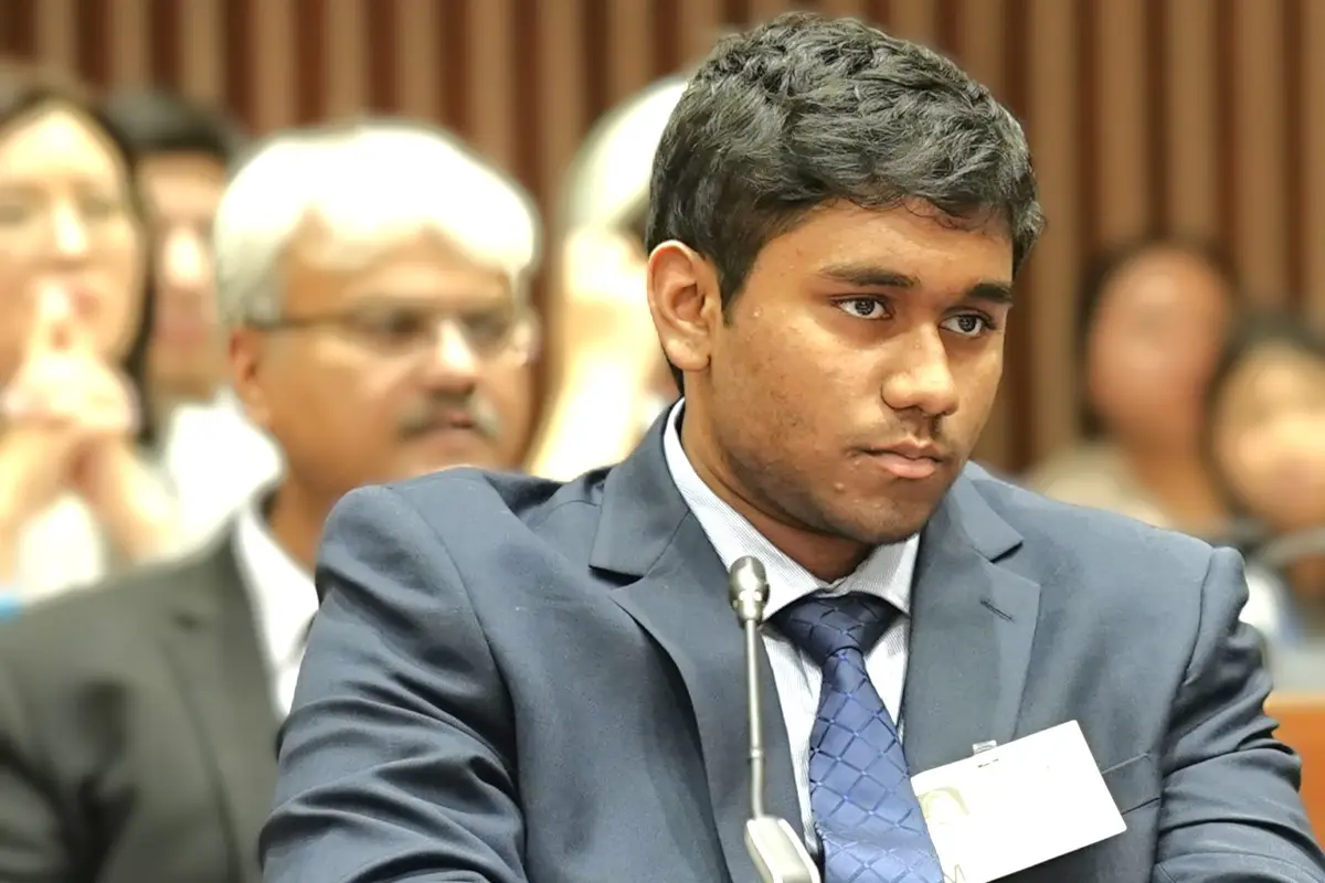 Oakton High School student Khartik Uppalapati sits in front of a microphone at World Bank conference