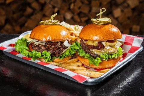 two burgers from charred on platter